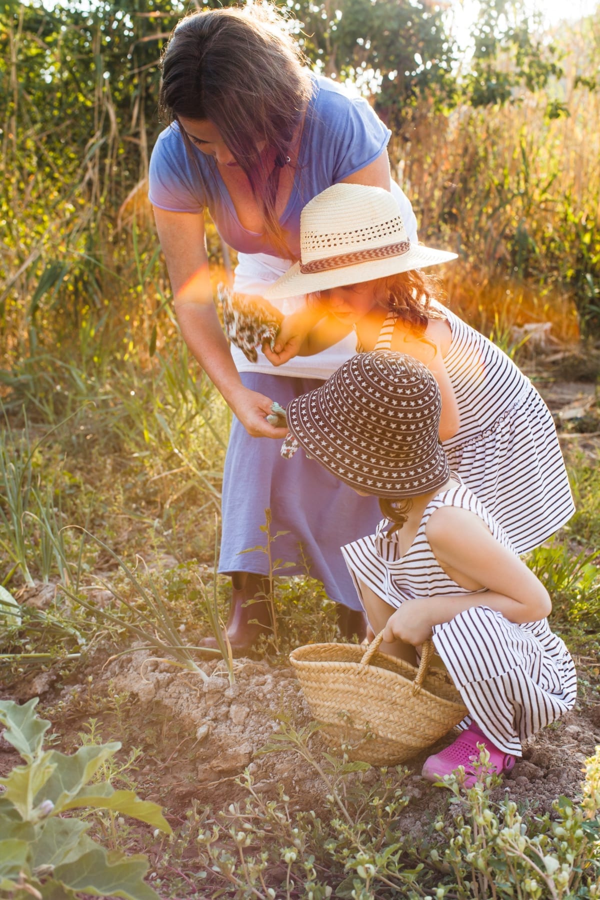 Una mujer comparte con dos niñas una experiencia de cultivo y recolección